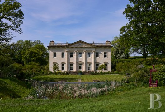 Aux portes des Cotswolds, à Wotton-under-Edge, une demeure de style georgien et ses annexes, édifiées en pierre ...