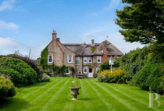 Dans le hameau de Benville, au cœur du Dorset rural,  une demeure géorgienne classée du 18e siècle, son toit ...