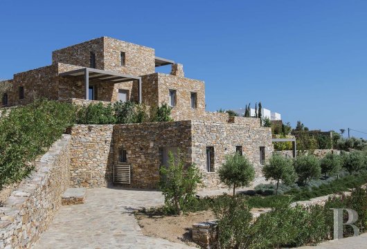 Sur les collines de Sifnos, une villa en pierre avec deux maisons d'hôtes indépendantes face à la mer Égée