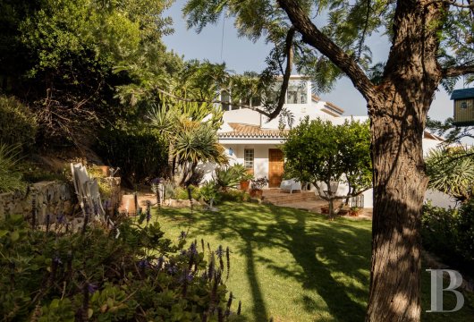 Dans l'arrière-pays de Faro, à Santa Bárbara de Nexe, une villa posée sur un terrain en terrasses planté d'arbres ...